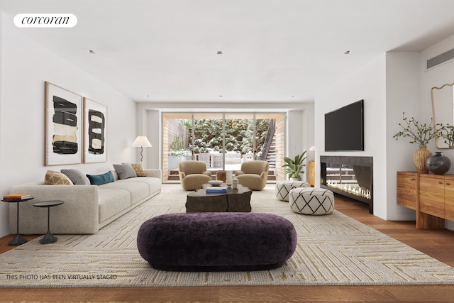 living room with wood finished floors, visible vents, and a fireplace