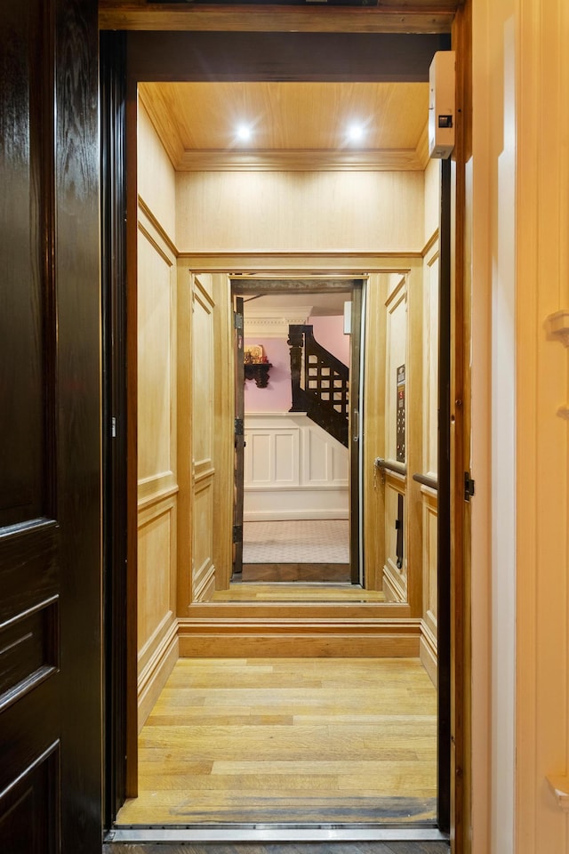 interior space with wooden ceiling, crown molding, and wood finished floors