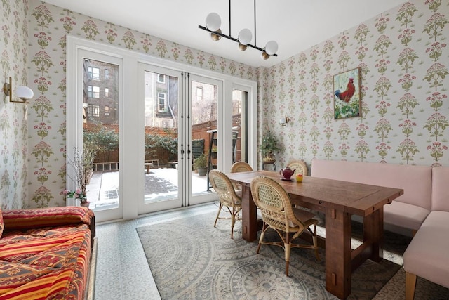 dining room with an inviting chandelier and wallpapered walls