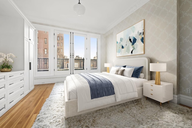 bedroom with wallpapered walls, light wood finished floors, and ornamental molding