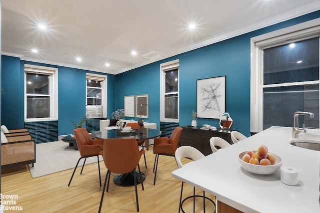 dining area with sink, light hardwood / wood-style flooring, and ornamental molding