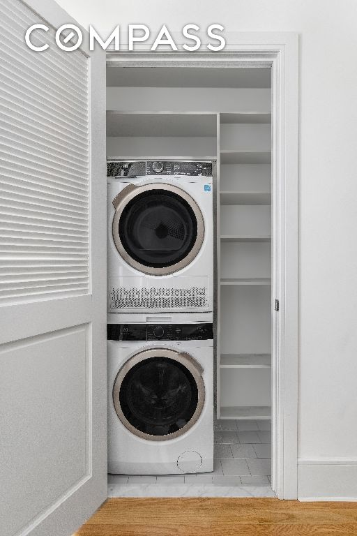 washroom featuring stacked washer / drying machine