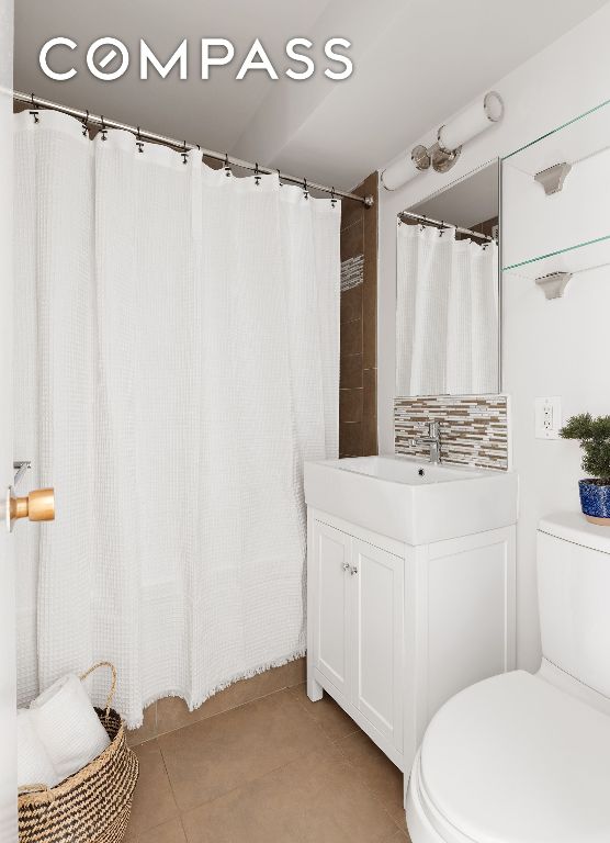 bathroom featuring vanity, tile patterned floors, and toilet