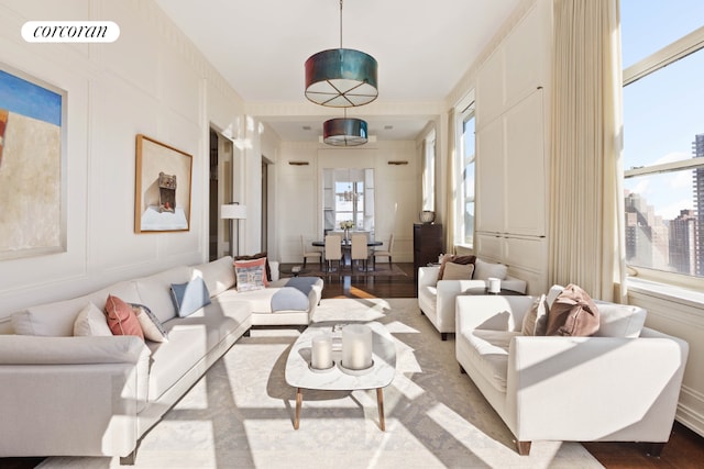 living area featuring a view of city, visible vents, a decorative wall, and wood finished floors