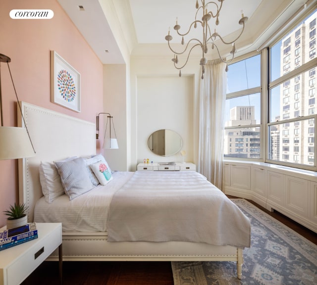 bedroom featuring an inviting chandelier, crown molding, and dark wood-type flooring