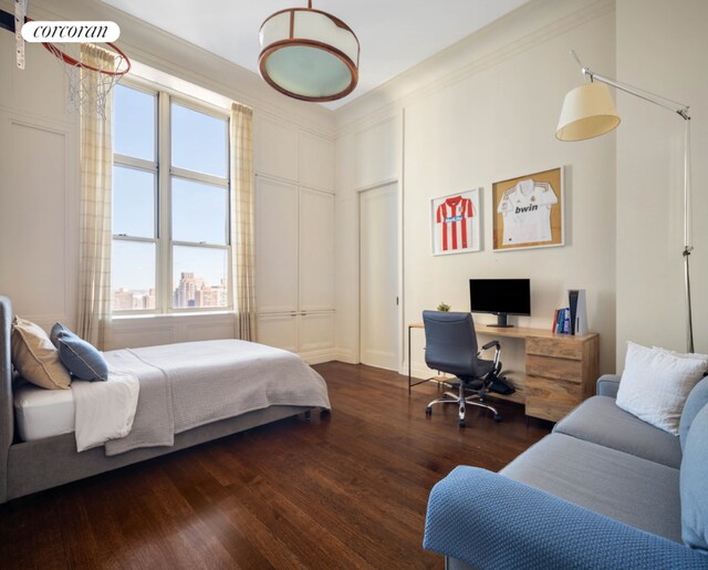 bedroom with ornamental molding and dark hardwood / wood-style floors