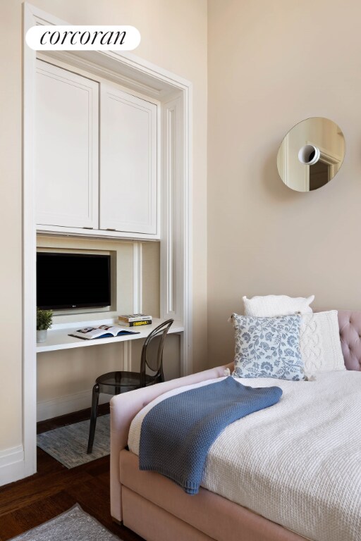 bedroom featuring dark wood-type flooring and built in desk