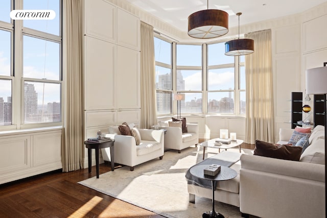 living room featuring dark wood-type flooring, a decorative wall, and a city view