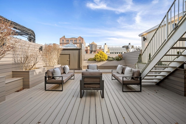 wooden terrace with outdoor lounge area, an outdoor structure, a fenced backyard, and a shed