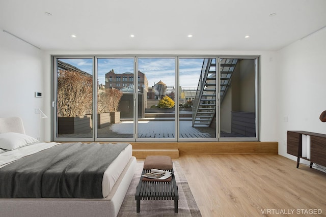 bedroom with access to outside, multiple windows, recessed lighting, and wood finished floors