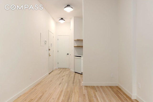 hallway with light wood-style floors and baseboards