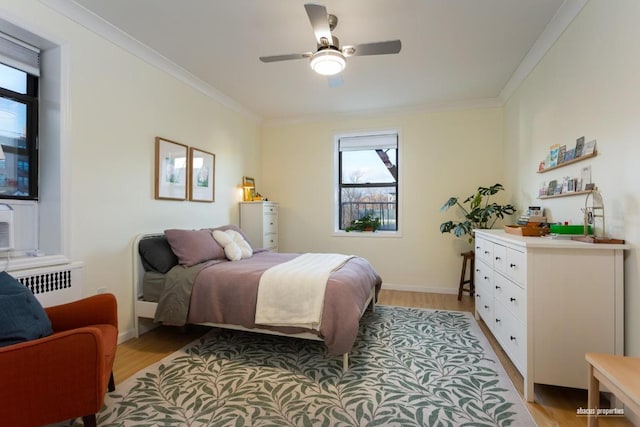 bedroom featuring light wood-style floors, radiator heating unit, ornamental molding, and baseboards