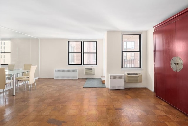 unfurnished living room with radiator and a wall mounted AC