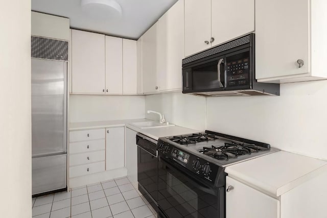 kitchen with white cabinetry, sink, black appliances, and light tile patterned flooring