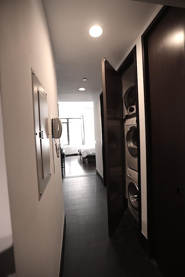 hallway featuring recessed lighting, baseboards, and stacked washer and dryer