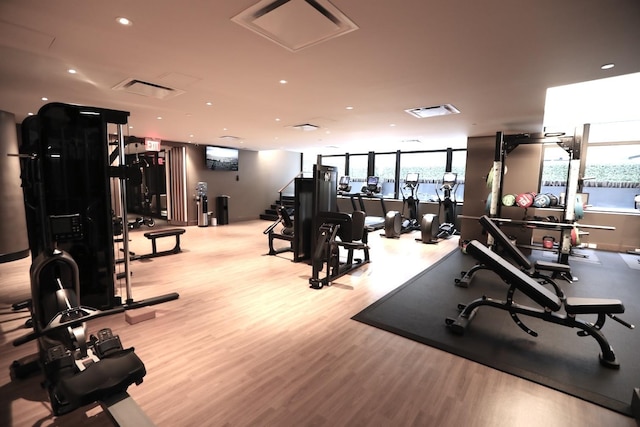 workout area with visible vents, recessed lighting, and wood finished floors