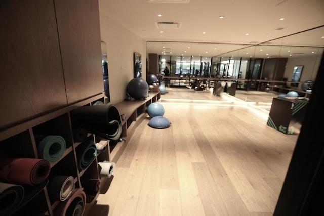 exercise room with light hardwood / wood-style flooring