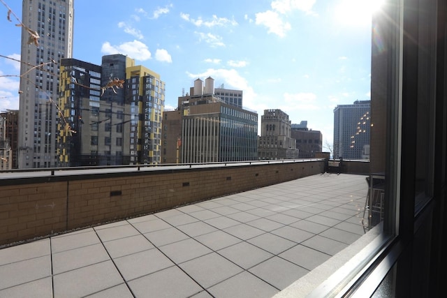 view of patio / terrace with a view of city and a balcony