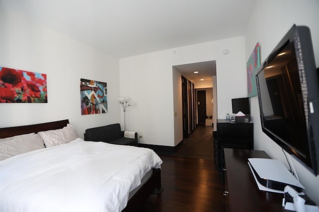 bedroom with dark wood-style flooring