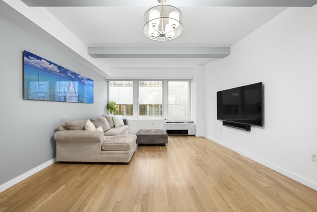 living room featuring beamed ceiling, a chandelier, and light hardwood / wood-style flooring