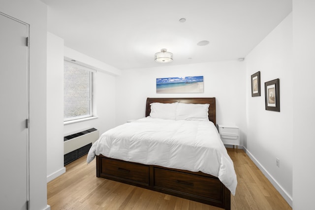 bedroom with radiator and light hardwood / wood-style flooring