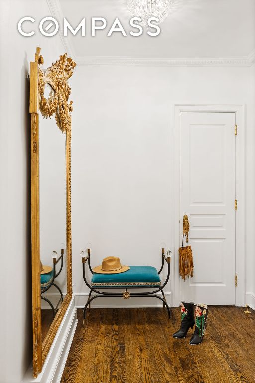 interior space featuring ornamental molding and dark wood-type flooring