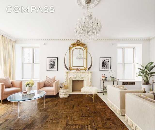 living room featuring an inviting chandelier, dark parquet flooring, and a fireplace