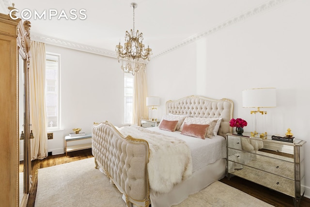 bedroom with a notable chandelier and wood finished floors