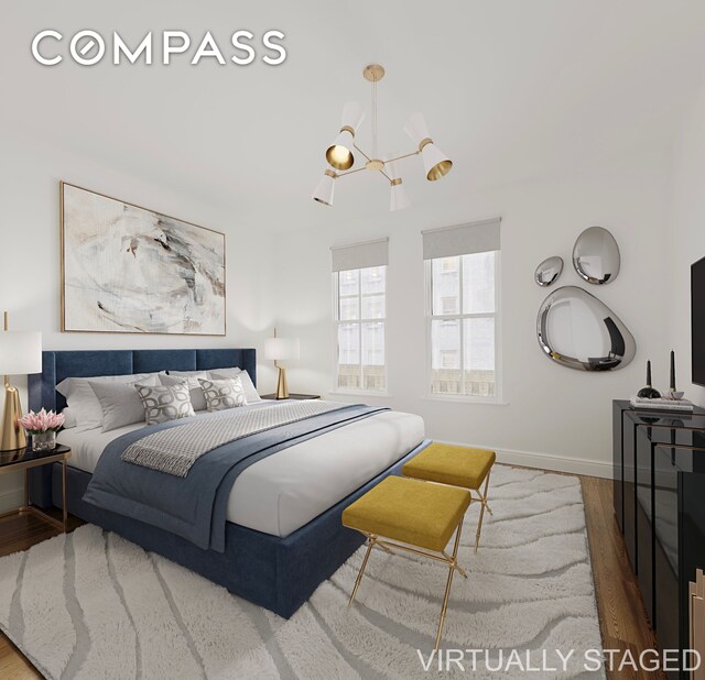 bedroom featuring baseboards, a notable chandelier, and wood finished floors