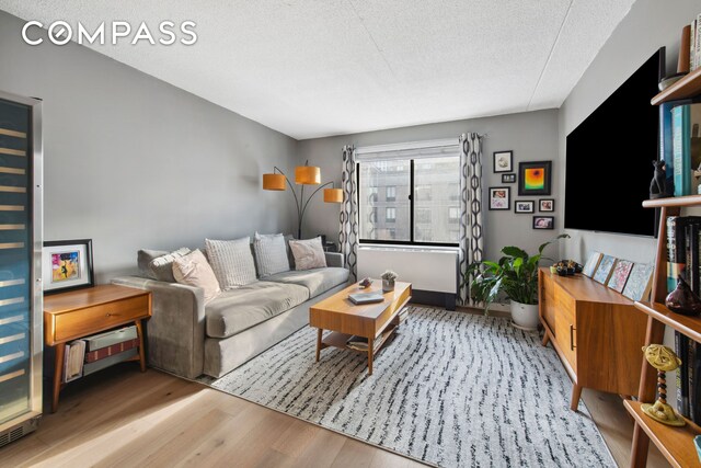 living room with light hardwood / wood-style floors and a textured ceiling