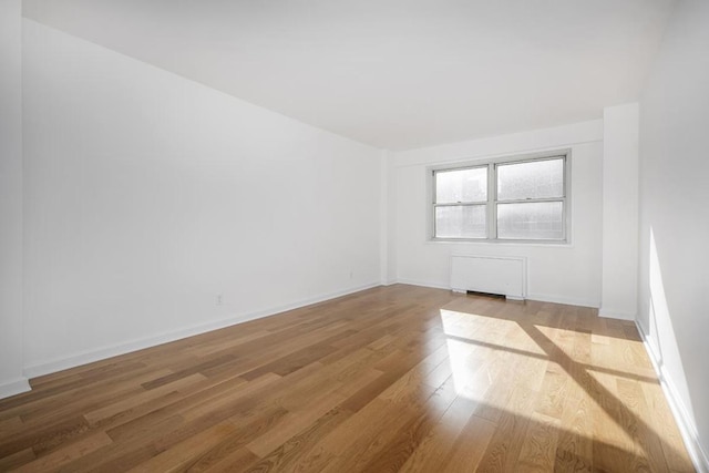 spare room with radiator and light hardwood / wood-style flooring