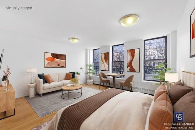 bedroom with multiple windows and light hardwood / wood-style floors