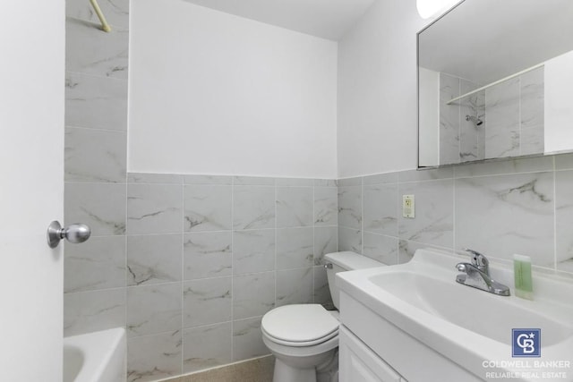 bathroom with vanity, tile walls, and toilet