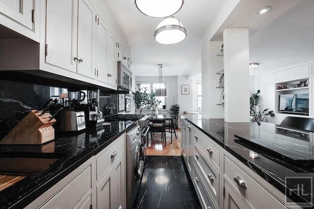 kitchen with stainless steel microwave, backsplash, dark stone countertops, white cabinets, and washer / clothes dryer