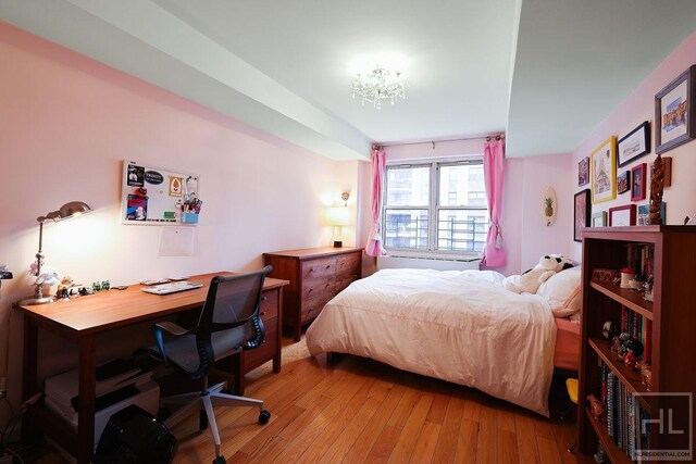 bedroom featuring a notable chandelier and wood-type flooring