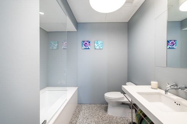 full bath featuring toilet, speckled floor, a sink, visible vents, and a tub