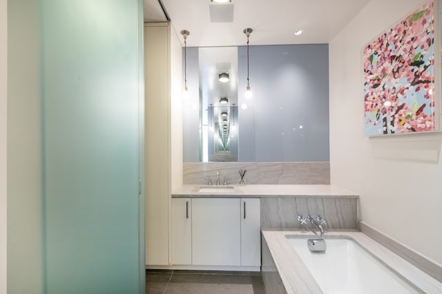 bathroom with vanity, tile patterned floors, and tiled bath