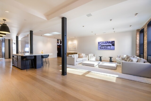 hall featuring brick wall and light wood-type flooring