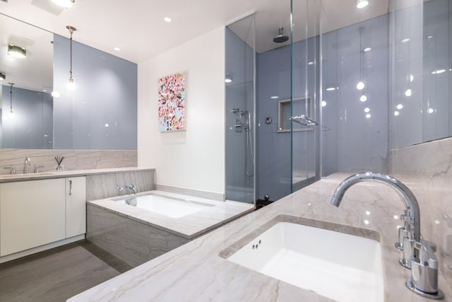 bathroom featuring a garden tub, vanity, and walk in shower