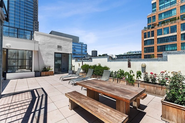 view of patio featuring outdoor dining area and a city view