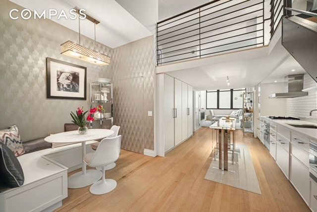 dining room featuring wallpapered walls, light wood-style flooring, and breakfast area