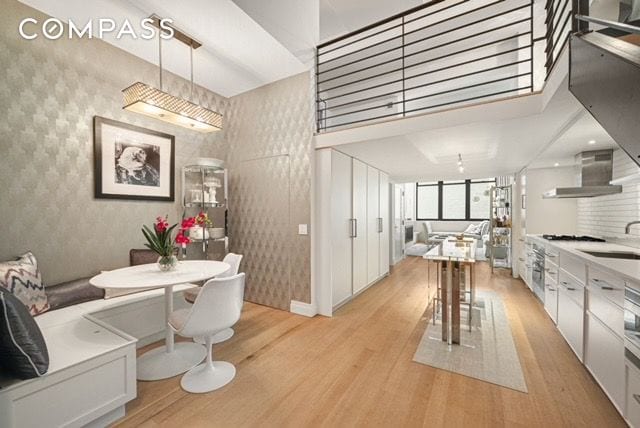 dining room with light wood-type flooring and wallpapered walls