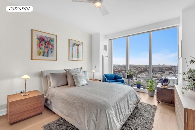 bedroom featuring light wood-style floors, visible vents, and a ceiling fan