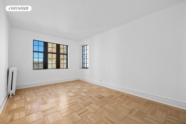 empty room with radiator, visible vents, and baseboards