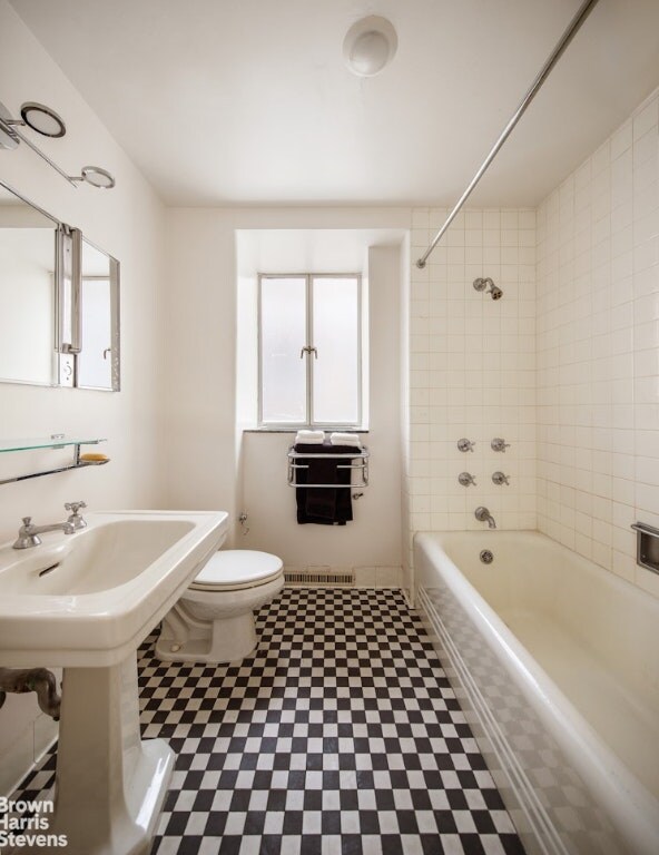 bathroom with tiled shower / bath and toilet