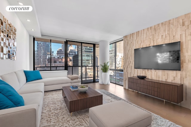 living room with a wall of windows and light hardwood / wood-style floors