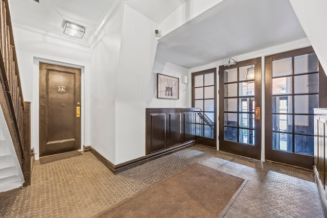 doorway to outside with baseboards and crown molding