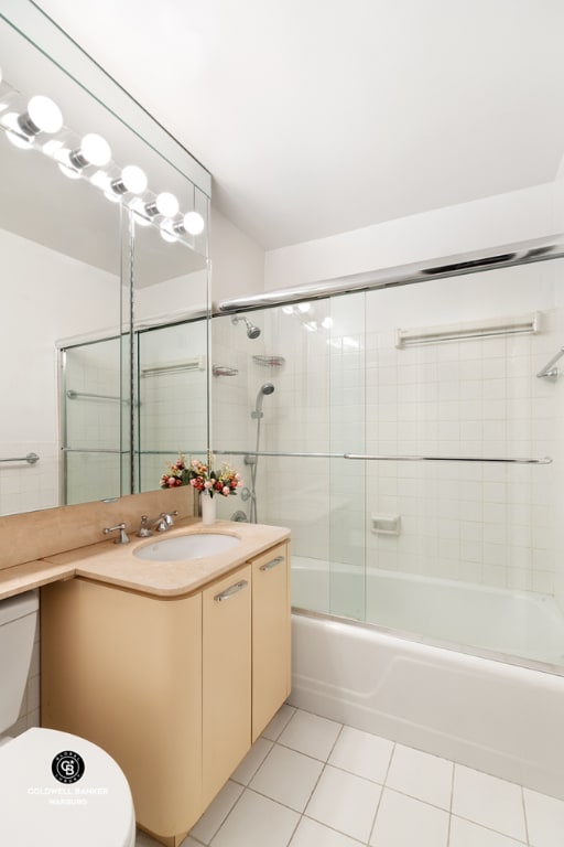 full bathroom featuring bath / shower combo with glass door, vanity, toilet, and tile patterned flooring