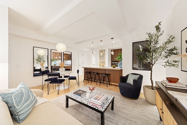 living room with beamed ceiling and light hardwood / wood-style flooring