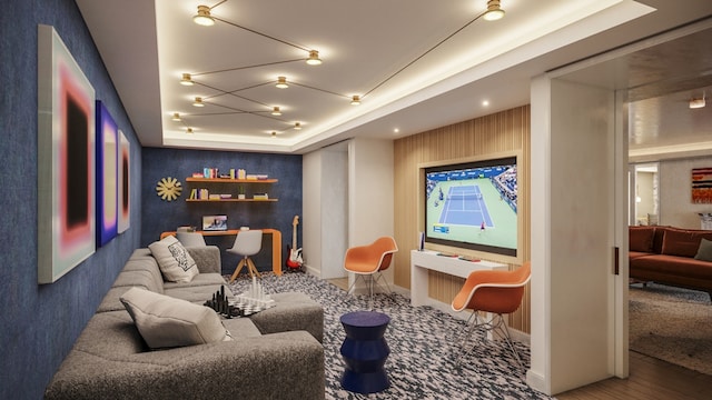 home theater room featuring a tray ceiling and baseboards